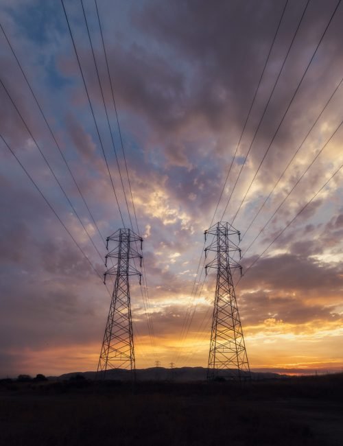 A low angle shot of electricity wires under a beautiful sunset sky