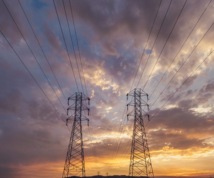 A low angle shot of electricity wires under a beautiful sunset sky
